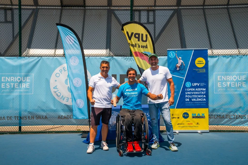Entrega de premios en pista: jugador en silla con trofeo, equipo y pancartas del Open AEEPIM y UPV